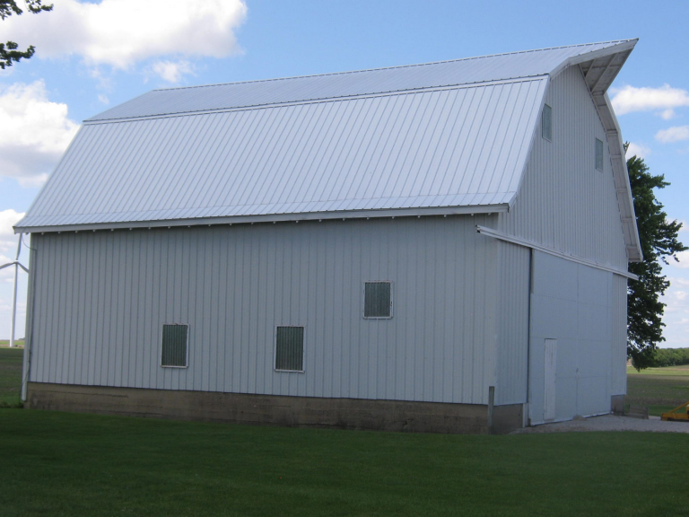 A white barn, with a tin roof.